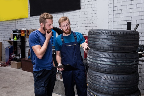 KFZ-Mechaniker weist Kunden auf Gefahren für Reifenschäden durch falsche Lagerung hin.